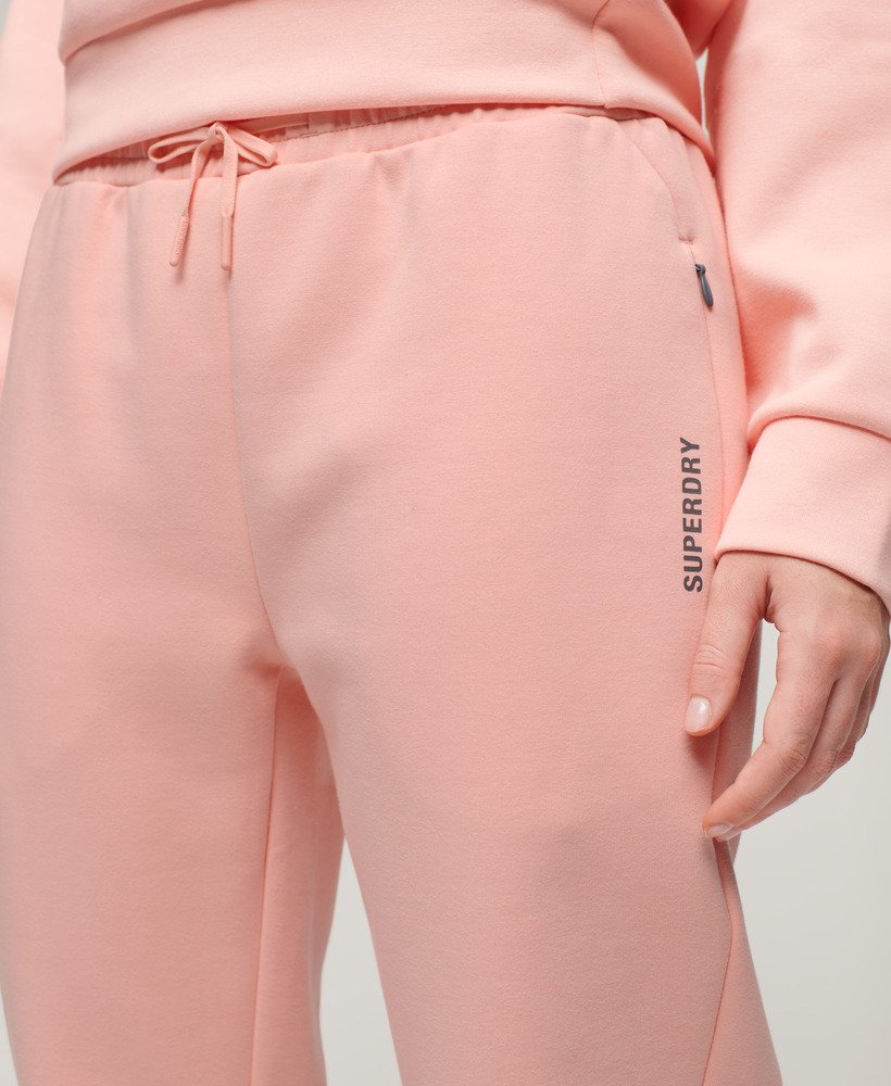 spodnie dresowe sports tech slim joggers w kolorze brzoskwiniowo-perłowym